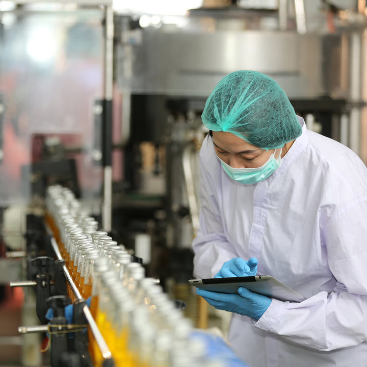 worker controlling the work of machine in production line at beverage industry.